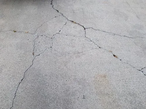 Close-up of a cracked concrete driveway slab on a Metro Vancouver property